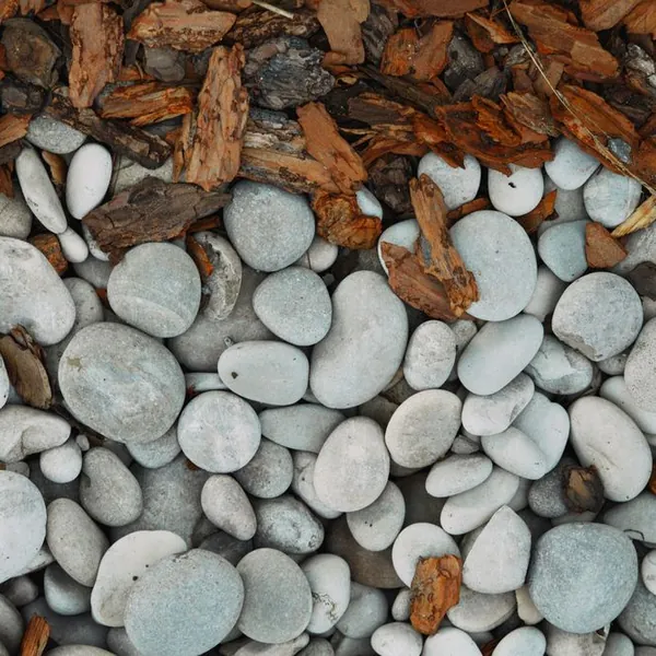 Fresh bark mulch and decorative river stone in a landscaped bed